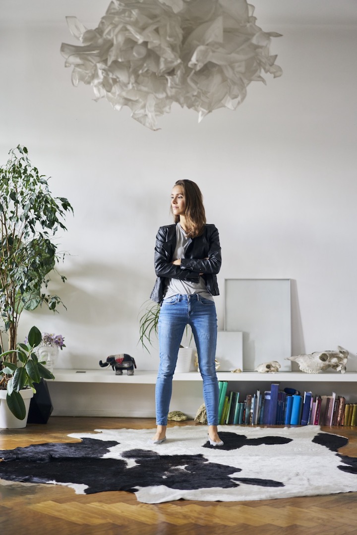 Woman analyzing bulky items to get rid of in order to create a minimalist environment in her living room.
