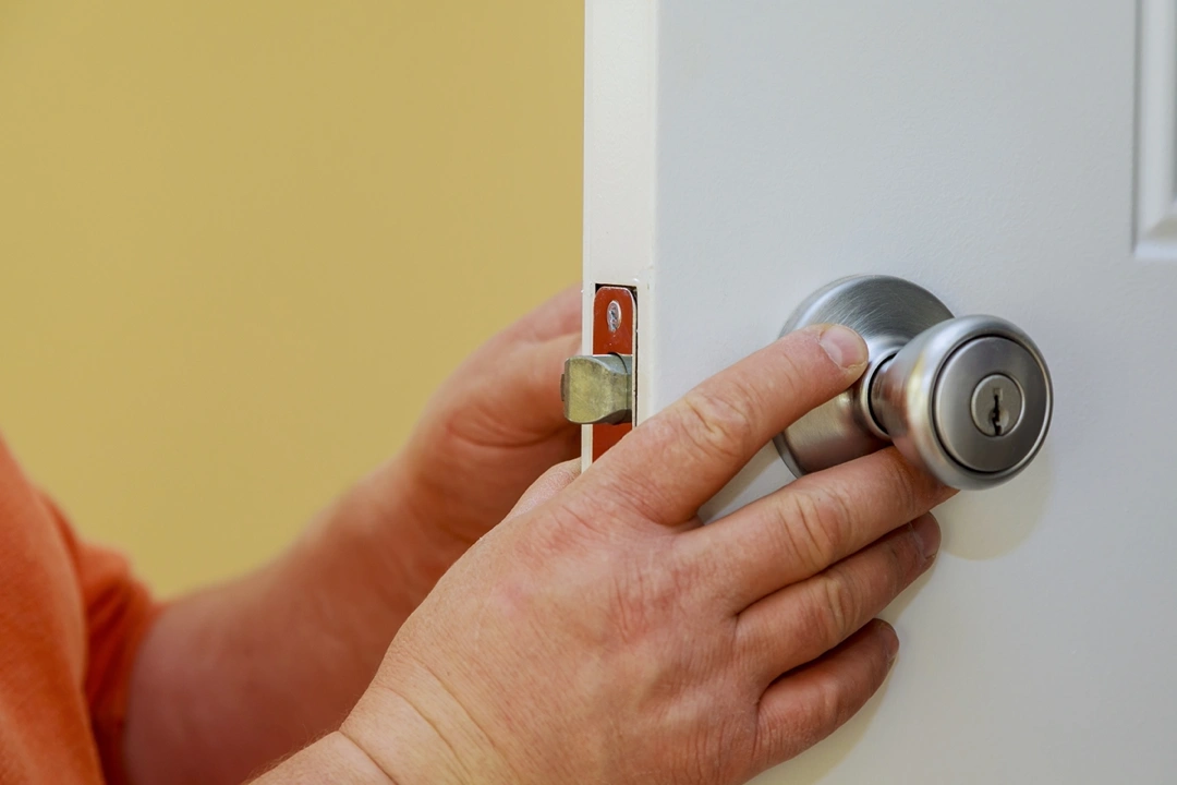 A man installing a door handle.