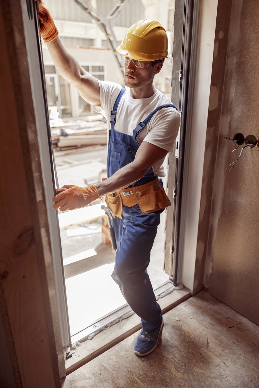 A man measuring a doorframe.